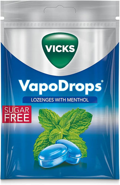 The Vicks VapoDrops Menthol Sugar Free Lozenges (72 g) pack features a green logo and Lozenges with Menthol, depicting two blue lozenges and mint leaves. A red Sugar Free label highlights these cooling treats that provide soothing relief.