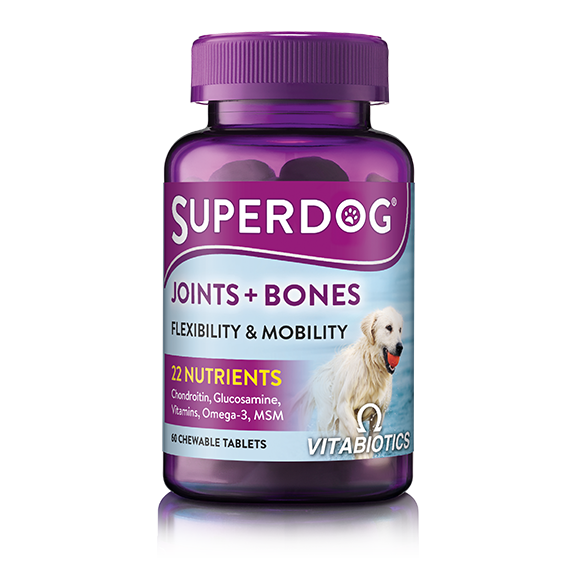The Vitabiotics Superdog Joints And Bones bottle, in purple, features a dog image and advertises Flexibility & Mobility benefits with 22 nutrients like glucosamine, chondroitin, omega-3s, vitamins, and MSM. It offers an ideal joint supplement with 60 chewable tablets for dogs.