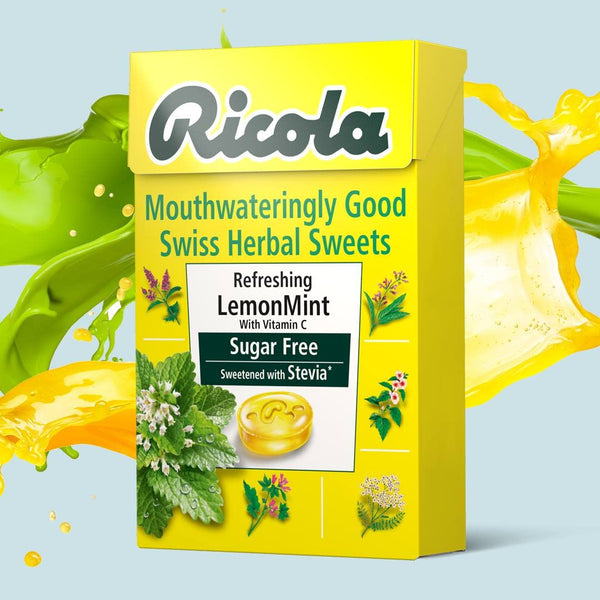 A yellow box of Ricola Swiss Herbal Sweets Sugar-Free Lemon Mint (45g) is shown with green and yellow splashes. These stevia-sweetened treats contain Vitamin C and are part of Ricolas trusted Swiss Herbal Sweets collection.