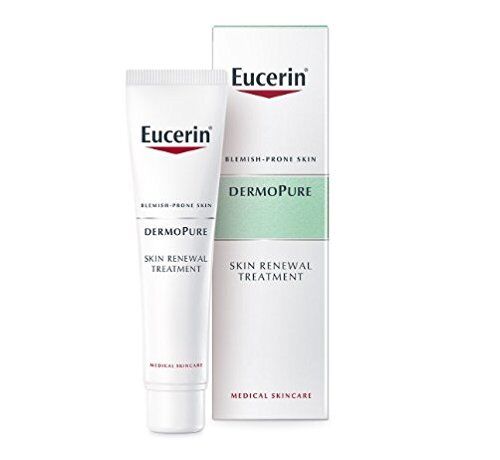 A tube of Eucerin Dermopurifyer Oil Control Skin Renewal Treatment (40ml) is shown with its box. The mostly white packaging, with minimalist text, emphasizes its potent formula to unclog pores and renew blemish-prone skin.