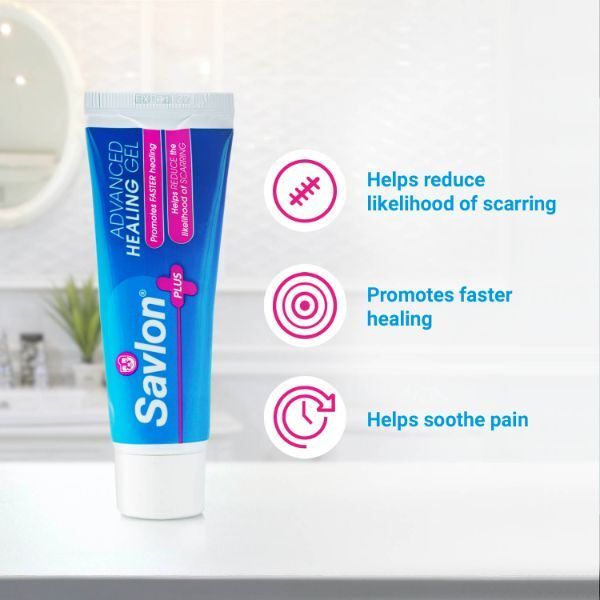 A 50g tube of Savlon Advanced Scar Prevention Gel rests on the bathroom counter. Text highlights three benefits—supports healing, promotes faster recovery, and helps prevent scars—each with matching icons.