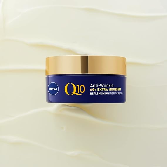 A blue and gold jar of Nivea Visage Q10 Power 60+ Night Cream (50ml), infused with organic argan oil, is centered on a textured, cream-colored background.