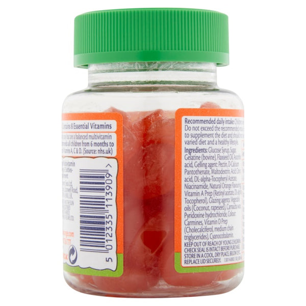 A clear plastic jar with a green lid contains Seven Seas Haliborange Mr Men Omega 3 & Multi-Vitamin Softies, visible through the transparent container. The label features nutritional info and a barcode, while the 30 red gummies are loosely packed inside.