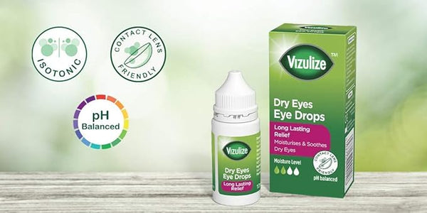 Image of a small bottle and box of Vizulize Dry Eyes Eye Drops (10ml) on a wooden surface. This isotonic, pH-balanced product ensures long-lasting comfort and is safe for contact lenses. The packaging is primarily green.