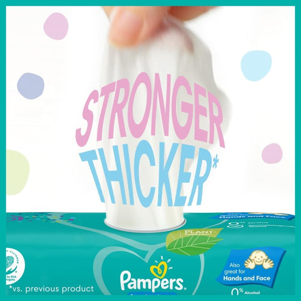 A hand pulls a wipe from a Pampers Fresh Clean Baby Wipes (52 Pack) package. Bold text reads STRONGER THICKER*; the packaging notes it’s great for hands and face as well. The vibrant, playful dotted design highlights these versatile Pampers wipes, ideal for everyday messes.