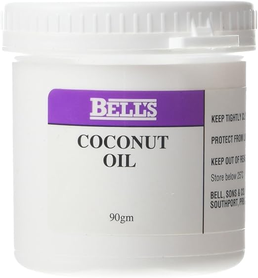 Bells Oils Coconut, a 90g white plastic jar, is known for deep hydration and moisturizing. The label features storage instructions and manufacturer details in black text on a white background with a purple band near the top.