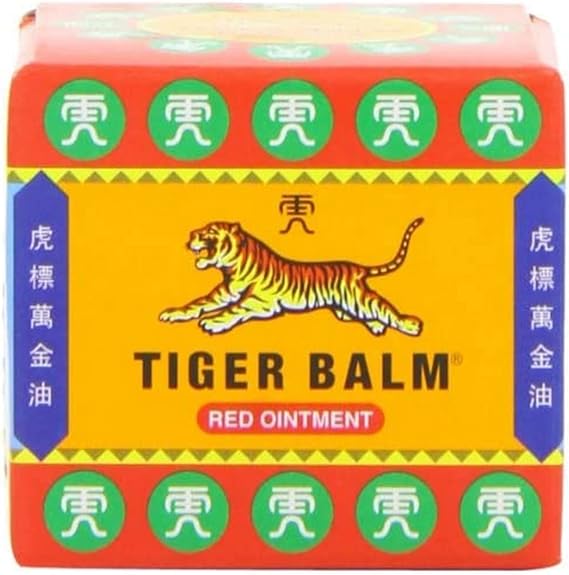 The 19g Tiger Balm Red Ointment box features a leaping tiger logo, green and red colors, and Chinese characters, highlighting its herbal contents. The Tiger Balm brand name boldly promises effective muscle pain relief.