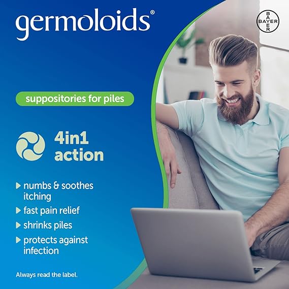 A smiling man in a light blue shirt sits on a couch using his laptop, with Germoloids Triple Action as the focus, a hemorrhoid treatment that offers numbing, pain relief, shrinking piles, and infection protection.