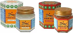 Two jars of Tiger Balm are shown with packaging. The left jar contains Tiger Balm White Ointment, and the right is Tiger Balm Red Ointment (30g), both providing relief for muscular pain. The boxes display tiger imagery and traditional designs.