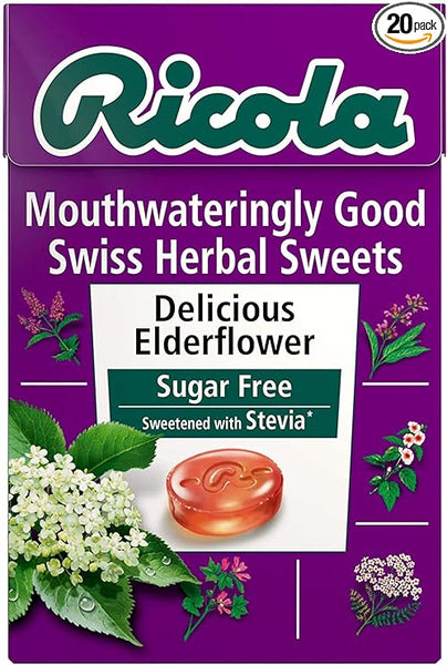 The Ricola Swiss Herb Drops Elderflower (45g) comes in a purple package adorned with elderflower and herb illustrations, featuring Delicious Elderflower flavor, Sugar-Free, and Sweetened with Stevia. Available in a convenient 20-pack.