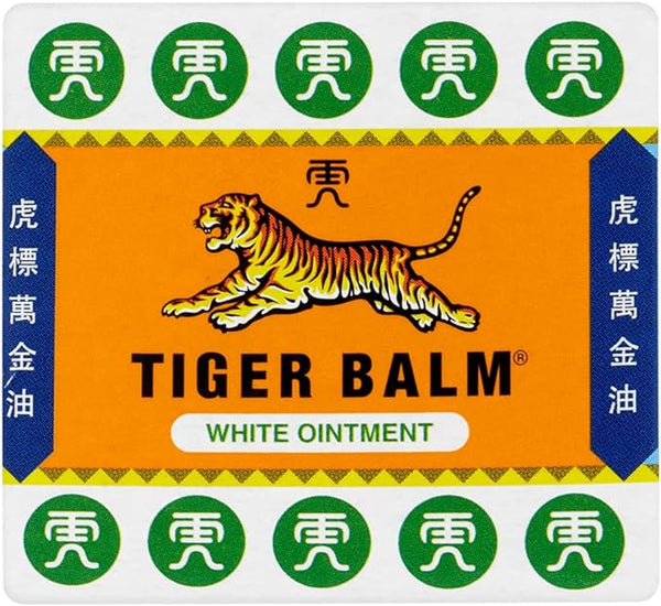 The packaging of Tiger Balm White Ointment (19g) features a yellow tiger on an orange background, with Tiger Balm White Ointment prominently below. Surrounding green and white symbols emphasize its reputation as a herbal pain relief ointment. Brand: Tiger Balm.