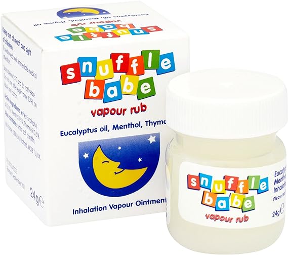 A small white jar of Snufflebabe Vapour Rub (24g) rests next to its colorful box, featuring a smiling crescent moon and stars. It promises relief from nasal congestion using natural essential oils like eucalyptus, menthol, and thyme. The playful product name is displayed on both the jar and box.