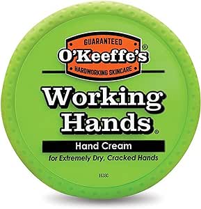 OKeeffes Working Hands Repair Cream (96g) comes in a green circular container, expertly moisturizing for extremely dry, cracked hands. The label boasts Guaranteed Hardworking Skincare with a distinctive orange and black logo.