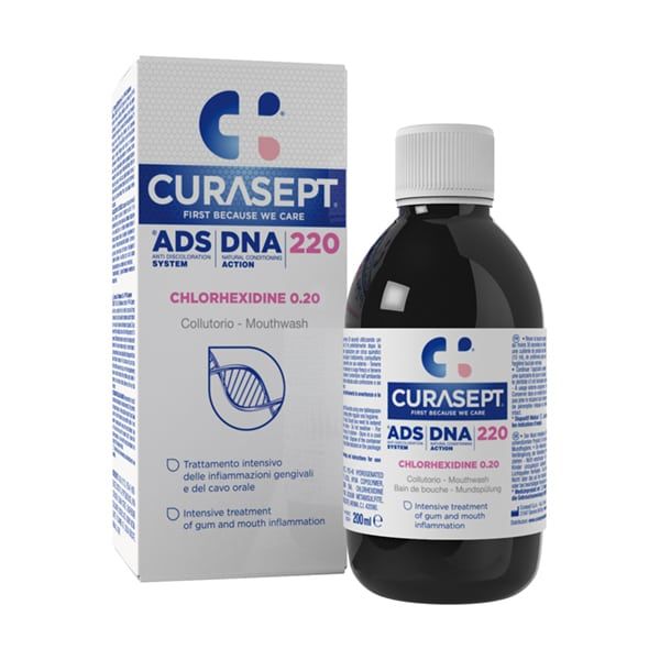 A bottle of Curasept ADS Mouthwash 220 - 0.20% (200ml) stands beside its box. It features an Anti Discolouration System and offers intensive treatment for gum and mouth inflammation. The packaging is predominantly white with blue and red accents.