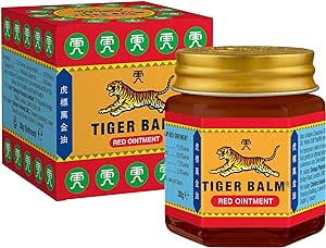 The Tiger Balm Red Ointment 30g, renowned for headache relief, comes in a jar with a gold lid and a label featuring a tiger and Chinese characters. The box mirrors this with vibrant red, yellow, green, and blue designs.