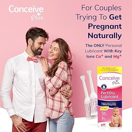 A smiling couple stands close together. The man sports a white shirt with a pink bow tie, and the woman wears a pink shirt. Text introduces Conceive Plus Fertility Lubricant Pre-Filled Applicators (8x4g) for couples trying to conceive, with applicators and the product box displayed.