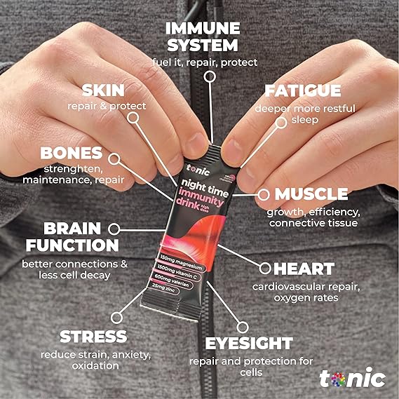 Close-up of a person holding a Tonic Night Time Immunity Drink sachet by Tonic Health. Labels highlight benefits for immune function, skin, bones, brain health, stress relief, fatigue reduction, muscles, heart health, and eyesight. This supplement also improves sleep quality. Person in gray jacket.