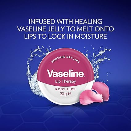 A Vaseline Lip Therapy Rosy (20g) container is surrounded by water splashes and rose petals. The text states, Infused with healing Vaseline jelly for hypoallergenic dry skin relief. A blue hexagonal pattern forms the background.