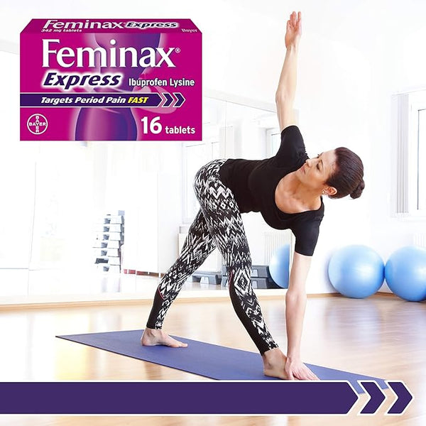 A woman practices yoga indoors on a mat, wearing a black top and patterned leggings. A box of Feminax Express 342mg Tablets (16 Tablets) sits nearby, offering period pain relief. Exercise balls are in the background, suggesting her commitment to holistic well-being.