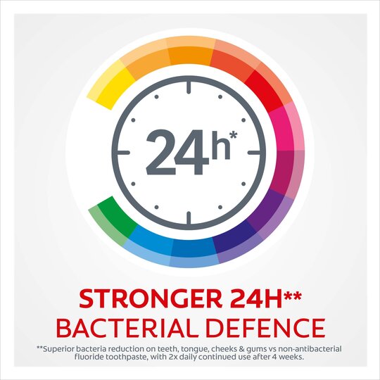 A clock graphic with 24h is set within a multicolored gradient circle. The text states: Stronger 24H Bacterial Defence. Fine print notes oral hygiene advantages and comprehensive protection with Colgate Total Advanced Toothpaste (125ml), promoting superior bacterial reduction with continued use.