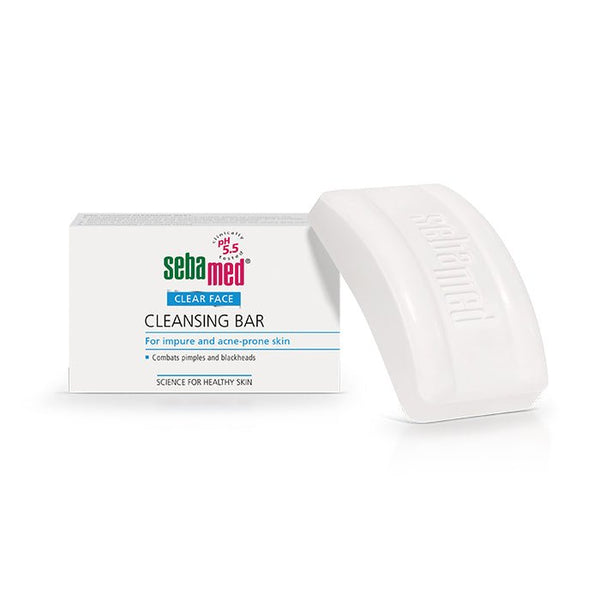 A Sebamed Cleansing Bar 100g for Eczema-Prone Skin Treatment beside its box highlights pore-deep cleansing for acne-prone skin, combating pimples and blackheads with a pH of 5.5. The white, curved soap is an effective acne treatment option from Sebamed.